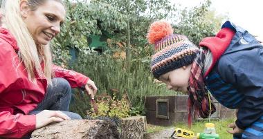 Child and adult exploring garden with raised beds