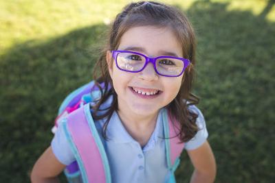 Photograph of smiling child with school backpack on