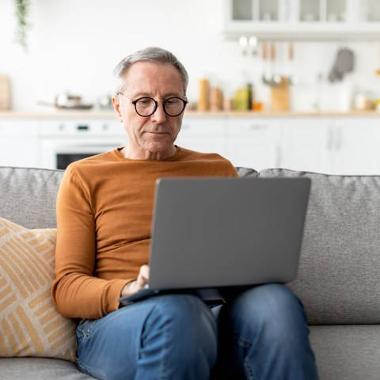 Person using a laptop on a sofa