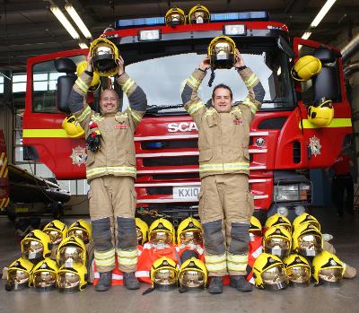 Picture of fire fighters holding old fire helmets