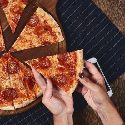 Person taking a slice of pizza 