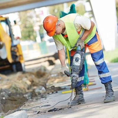Highway maintenance staff drilling into pavement 