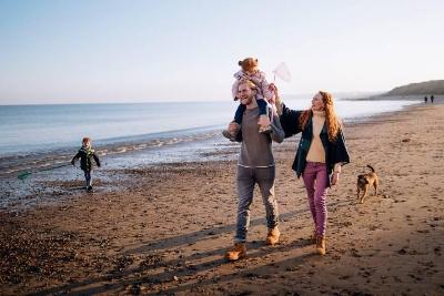 Family walking on beach in autumn
