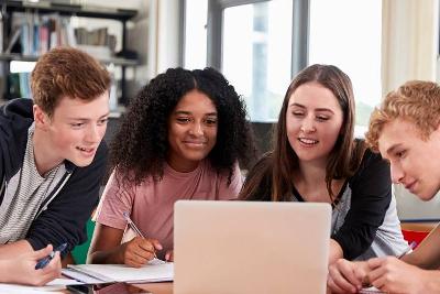 Group of young people looking at a laptop