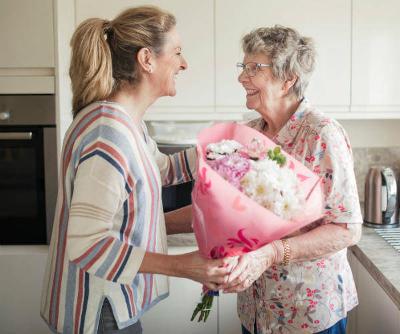 Person gifting flowers to their relative