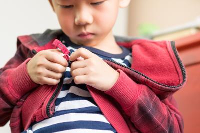 Preschool child zipping up jacket
