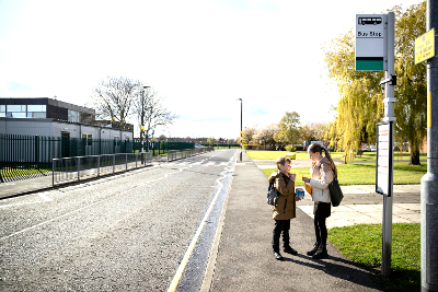Children waiting at bus stop outside school