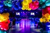 The event stage with two large screens showing the Flourish logo viewed through a balloon arch
