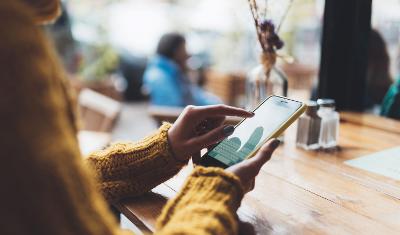 A woman's hands holding a mobile phone while she looks at it