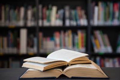 Photograph of two books, open, in a library