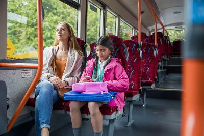 Photograph of adult and child sitting together on a bus