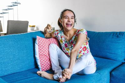 Really happy older teenage girl relaxing on a sofa