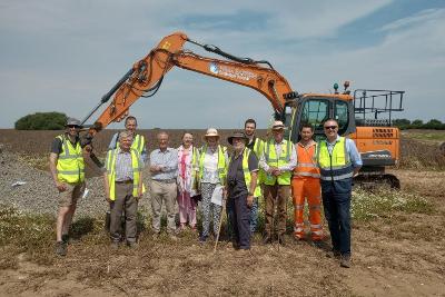 Photograph of people standing in front of construction machinery