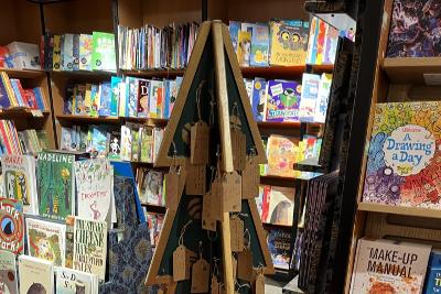 Photograph of wooden Christmas tree with labels on it in a bookshop