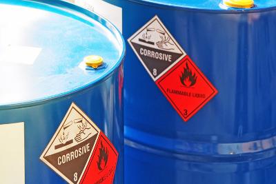 Canisters with signs saying flammable liquid and corrosive