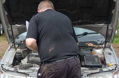 A person checks the engine of a car
