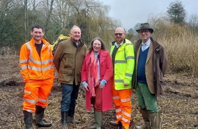 Members of the Norfolk Strategic Flooding Alliance standing at the site of works