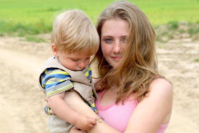 Teenage girl cuddling young boy toddler