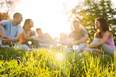 Young people sitting on a hill on a sunny day